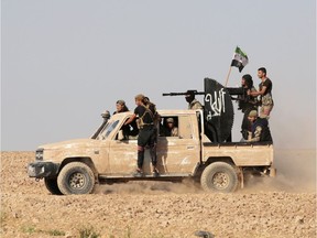 Turkey-backed Syrian rebel fighters ride on a truck mounted with a weapon in the village of Yabisa, near the Turkish-Syrian border, Syria, October 13, 2019.