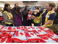 Then-newly-arrived Syrian refugee Anjilik Jaghlassian, centre, and her family receive winter clothes and other items at Pearson International airport, in Toronto on Dec. 11, 2015.