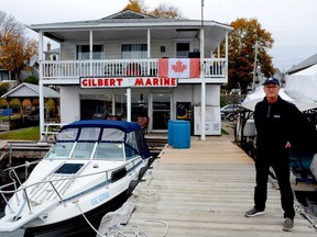 Nelson Gilbert stands in front of his 115-year-old family business, Gilbert Marine, on Wednesday. Until recently, the water covered the docks on which he is standing.