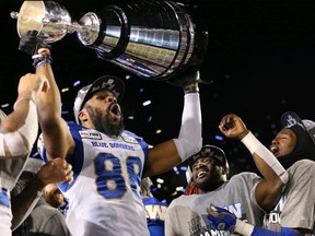 The Winnipeg Blue Bombers' Rasheed Bailey raises the Grey Cup with teammates as they celebrate defeating the Hamilton Tiger-Cats 33-12 to win the 107th Grey Cup in Calgary on Sunday.