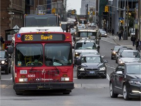 OC Transpo buses and cars travel east along Slater Street.