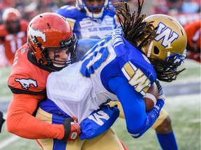Calgary Stampeders Nate Holley stops Winnipeg Blue Bombers Janarion Grant during the CFL's West Division semifinal at McMahon Stadium on Sunday.