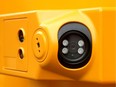 Closeup of stop arm camera unit on the side of a school bus.