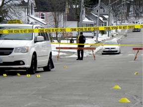 A Brockville Police officer is seen across crime scene tape as evidence markers line the ground at the scene of a homidice on Cedar Street in Brockville on Monday morning, Nov. 18, 2019.