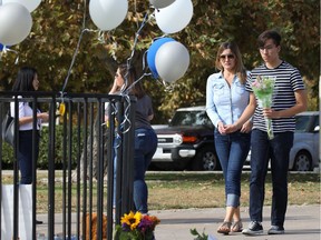A Saugus High School student brings flowers to a makeshift memorial in Central Park to victims of the shooting at the school on November 15, 2019 in Santa Clarita, California.