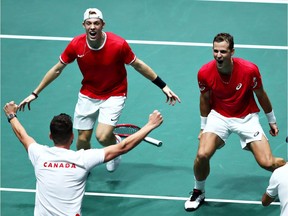 Vasek Pospisil and Denis Shapovalov of Canada celebrate with Canada team captain Frank Dancevic after winning the match in the quarter- final doubles match between Australia and Canada during Day 4 of the 2019 Davis Cup at La Caja Magica on November 21, 2019 in Madrid.