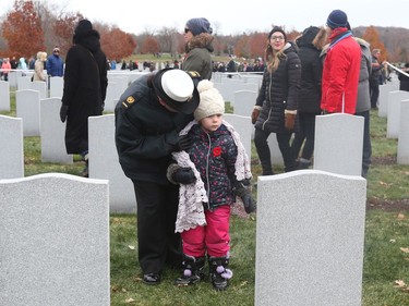 Nadia Lizotte and her daughter Chloé, 4 years old,  pay their respects during the Remembrance Day Ceremony at the National Military Cemetery, November 11, 2019.