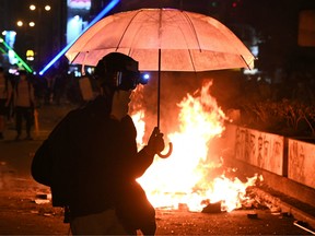 Protesters set a fire as they march to Hong Kong Polytechnic University in Hong Kong on November 18, 2019.