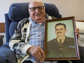 Maj. Alex Kowbel  holds a painted portrait of himself when he was in Japan in the 1950s.