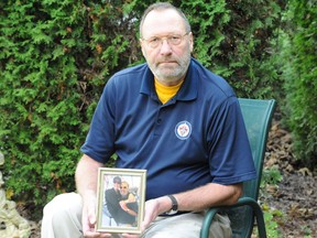 Retired Royal Canadian Navy Capt. Kevin Carle holds a photo of himself and his sister, Krista, a former RCMP officer who faced sexual harassment and assault during her service with the police force. She committed suicide in 2018.