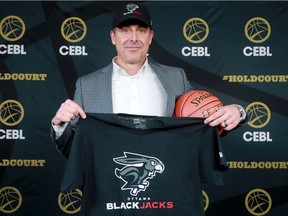 Mike Morreale, commissioner and CEO of the Canadian Elite Basketball League, shows off the logo of the Ottawa BlackJacks during a media conference on Nov. 20.