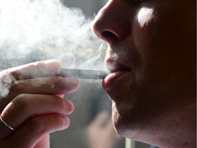 An October 2018 file photo shows a man exhaling smoke from an electronic cigarette in Washington.