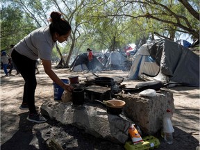 A woman cooks in the Matamoros camp, in Matamoros, Tamaulipas state, Mexico, near the border with the United States. More than 2,000 refugees are currently living in tents next to the International Bridge that connects the Mexican city of Matamoros with the US city of Brownsville.