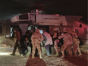 Handout picture released by the Health Secretary of Sonora state media office showing medical personnel of the Health Secretary and of the Mexican Air Force transferring five members of the Lebaron family after being injured during an gunmen ambush in the limits of Sonora and Chihuahua in Hermosillo, Mexico, on Tuesday