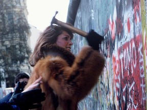 Picture taken in November 1989 and made available on November 9, 2019 shows a wall-pecker trying to tear down remains of the Berlin Wall in Berlin. - Germany celebrates 30 years since the fall of the Berlin Wall ushered in the end of communism and national reunification, as the Western alliance that secured those achievements is increasingly called into question.