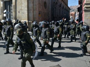 Officers of the Police Special Operations Tactical Unit (UTOP in Spanish) head to their headquarters at the Plaza de Armas square in La Paz, on November 9, 2019, after announcing they were joining a rebellion launched on the eve by other units in the central city of Cochabamba. - Police in three Bolivian cities joined anti-government protests Friday, in one case marching with demonstrators in La Paz, in the first sign security forces are withdrawing support from President Evo Morales after a disputed election that has triggered riots.