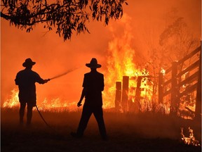 Residents defend a property from a bushfire near Taree, 350 kilometres north of Sydney, on Tuesday.