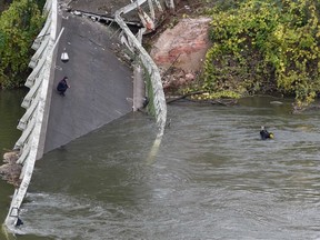 Rescuers dive in the River Tarn near a suspension bridge which collapsed on November 18, 2019, in Mirepoix-sur-Tarn, near Toulouse, southwest France. - A 15-year-old girl was killed after a suspension bridge over a river collapsed on November 19, causing a car, a truck and possibly a third vehicle to plunge into the water, local authorities said. Four people were rescued but several others were feared missing after the collapse of the bridge linking the towns of Mirepoix-sur-Tarn and Bessieres, 30 kilometres (18 miles) north of the city of Toulouse, said fire service and local security chief Etienne Guyot.