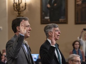 Career Foreign Service officer George Kent, left, and top U.S. diplomat in Ukraine William Taylor, right, are sworn in to testify before the House Intelligence Committee on Capitol Hill in Washington, Wednesday, Nov. 13, 2019, during the first public impeachment hearings on President Donald Trump's efforts to tie U.S. aid for Ukraine to investigations of his political opponents.