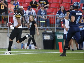The Hamilton Tiger-Cats' Rico Murray looks back as he runs the ball into the end zone.