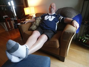 Winnipeg Blue Bombers' fan Chris Matthew, who has been wearing shorts daily since the 2001 Grey Cup in Calgary, relaxes in his living room in Winnipeg Wednesday, November 20, 2019. With the Blue Bombers' decisive 33-12 win over Hamilton in the 107th Grey Cup, Matthew is due for a wardrobe upgrade after 18 years and told CTV News he has plans to go shopping.