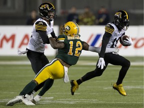 The Edmonton Eskimos' Forrest Hightower battles the Hamilton Tiger-Cats' Mike Jones (12) and Brandon Banks (16) in a September 2019 game. Banks had a league-leading 1,550 yards in catches in just 16 games, with 13 touchdowns.