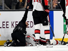 A Senators medical staff member calls for assistance while tending to winger Scott Sabourin, who was knocked unconscious by a collision with Bruins winger David Backes during a game on Nov. 2 in Boston.