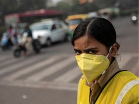 A policewoman wears a mask to protect herself from air pollution at a junction during restrictions on private vehicles based on registration plates on a smoggy morning in New Delhi, India, November 4, 2019.