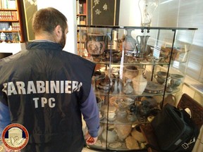 Carabinieri military policeman looks at artefacts in a display case in Cosenza, Italy, November 18, 2019