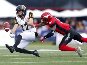 Hamilton Tiger-Cats Luke Tasker (left) get tackled by Calgary Stampeders Emanuel Davis during their game at McMahon Stadium in Calgary, on Saturday June 16, 2018.
