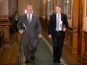 Ontario's Finance Minister Rod Phillips, right, is accompanied by Ontario Premier Doug Ford as he walks to the Ontario Legislative Chamber to deliver the fall fiscal update, in Toronto on Nov. 6, 2019.