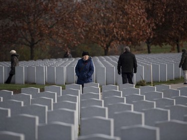 People walk among the graves before a Remembrance Day ceremony at the National Military Cemetery at Beechwood Cemetery in Ottawa, on Monday, Nov. 11, 2019.