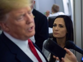 In this file photo taken on August 8, 2019 White House Press Secretary Stephanie Grisham listens as US President Donald Trump speaks to the media aboard Air Force One while flying between El Paso, Texas and Joint Base Andrews in Maryland.