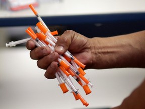 Files: Used needles are shown at a needle exchange in Miami, May 6, 2019. Barring drug-using federal prisoners from access to clean syringes puts them at risk for serious diseases and violates their rights, an Ontario court is set to hear.