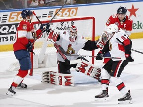 SUNRISE, FL - MARCH 3: Goaltender Anders Nilsson of the Ottawa Senators defends the net with Jonathan Huberdeau and Aleksander Barkov of the Florida Panthers at the posts in the final minute of the game at the BB&T Center on March 3, 2019 in Sunrise, Florida. The Senators defeated the Panthers 3-2.