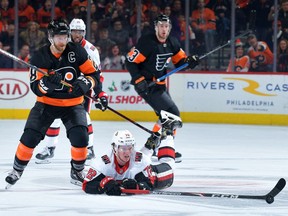 Thomas Chabot of the Ottawa Senators dives for the puck in front of Claude Giroux of the Philadelphia Flyers in the third period at Wells Fargo Center on Saturday, Dec. 7, 2019.