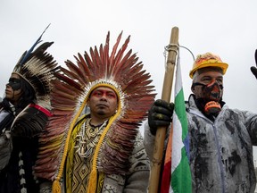 MADRID, SPAIN - DECEMBER 08: Indigenous leaders from Brazil and a demonstrator take part in a protest outside REPSOL Headquarters on December 08, 2019 in Madrid, Spain. Indigenous leaders and activists are protesting in Madrid against oil contamination and the fossil fuel industry in Brazil because of the damage it provokes to the poorest communities, sea life, food supplies and the climate.