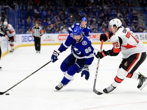 Nikita Kucherov #86 of the Tampa Bay Lightning and Thomas Chabot #72 of the Ottawa Senators fights for the puck during a game  at Amalie Arena on December 17, 2019 in Tampa, Florida.