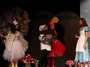 Students (L to R) Mallory Quinn as The White Queen, MJ Flores-Lyons as The Cook, Vanessa Czorny as The Red Queen, and Sophie Holcik as Alice perform during St Pius X High School's Cappies production of Alice's Adventures in Wonderland, on December 5, 2019,.