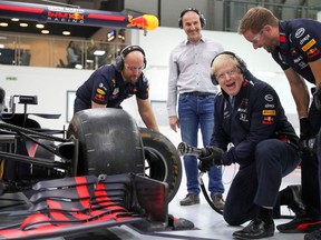 Britain's Conservative leader, Boris Johnson, changes the wheel of a Formula One (F1) car during a Conservative Party general election campaign visit to Red Bull Racing in Milton Keynes, north of London.