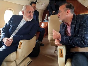 A handout picture released by the Iranian Foreign Minister's official Twitter account on  December 7, 2019, shows Foreign Minister Mohammad Javad Zarif (L) and Iranian scientist Massoud Soleimani speaking to each other while sitting in a plane at an undisclosed location.