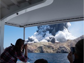 This handout photograph courtesy of Michael Schade shows the volcano on New Zealand's White Island spewing steam and ash moments after it erupted on December 9, 2019. - New Zealand police said at least one person was killed and more fatalities were likely, after an island volcano popular with tourists erupted on December 9 leaving dozens stranded.