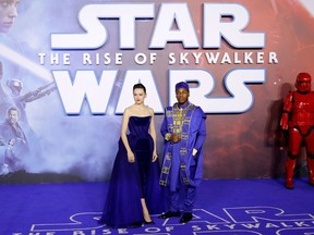 (FILES) In this file photo taken on December 18, 2019 British actor Daisy Ridley (L) and British actor John Boyega (R) pose on the red carpet upon arrival for the European film premiere of Star Wars: The Rise of Skywalker in London. Photo by Tolga AKMEN / AFP