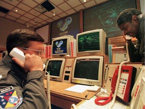 Missile Commanders Lt. (L) and Lt. Col. Ken Reed confirm a launch warning over the phone during a practice drill at the North America Aerospace Defense Command (NORAD) Cheyenne Mountain Complex in Colorado Springs, Colorado, 09 November, 1999.  With the coming of the year 2000, many were worried about whether or not the complex missile tracking system will be operational after computers switch to the new year.