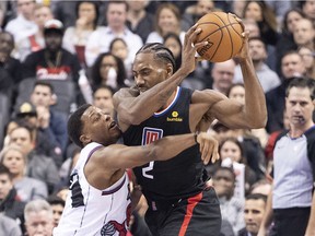 L.A. Clippers forward Kawhi Leonard controls the ball as Toronto Raptors guard Kyle Lowry tries to defend during the third quarter at Scotiabank Arena.