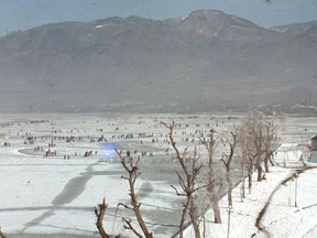 People enjoy skating on a frozen Lake Suwa in this handout photo taken around the 1950s, released by Suwa City Museum and obtained by Reuters on November 28, 2019