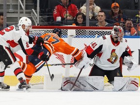 Edmonton Oilers' Connor McDavid is pushed for a penalty by Ottawa Senators' Dylan DeMelo  into goaltender Craig Anderson during the third period of a NHL hockey game at Rogers Place in Edmonton, on Wednesday, Dec. 4, 2019.