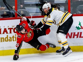The Ottawa Senators' Erik Brannstrom gets checked by the Boston Bruins' Chris Wagner.