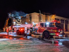 Firefighters work on a rooftop fire at a commercial building in South Gloucester Thursday night.