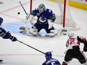 Ottawa Senators defenseman Thomas Chabot (72) shoots the puck against Vancouver Canucks goaltender Thatcher Demko (35) and defenseman Troy Stecher (51) during the third period at Rogers Arena.